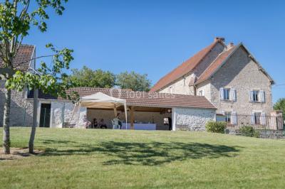 Un couple en tenue de mariage pose sur des rails entourés de verdure dans un cadre naturel et lumineux.