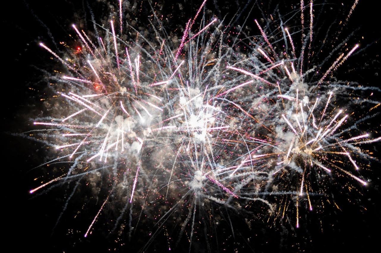 Feux d'artifice multicolores éclatant dans un ciel nocturne sombre.