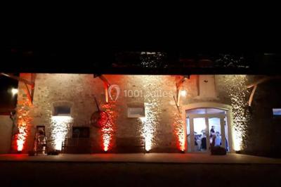 Un couple en tenue de mariage pose sur des rails entourés de verdure dans un cadre naturel et lumineux.