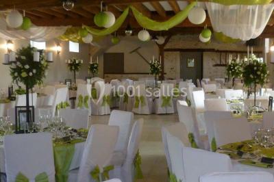Un couple en tenue de mariage pose sur des rails entourés de verdure dans un cadre naturel et lumineux.