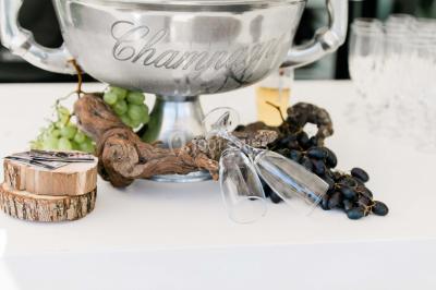Un couple en tenue de mariage se tient la main dans un jardin baigné par une lumière douce au coucher du soleil.