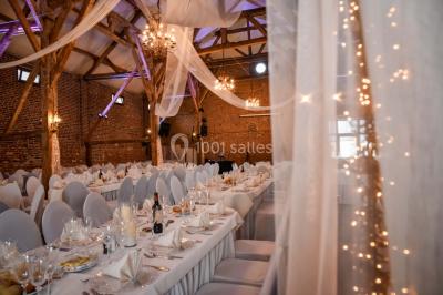 Un couple en tenue de mariage se tient la main dans un jardin baigné par une lumière douce au coucher du soleil.