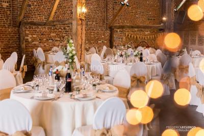 Un couple en tenue de mariage se tient la main dans un jardin baigné par une lumière douce au coucher du soleil.