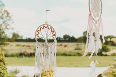 Un couple en tenue de mariage se tient la main dans un jardin baigné par une lumière douce au coucher du soleil.