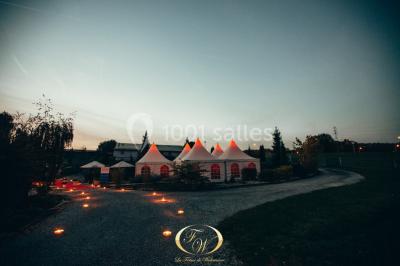 Plateau de bouchées apéritives variées présentées sur un napperon blanc, tenu par une personne en chemise blanche.