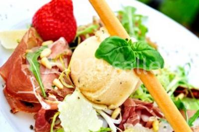 Plateau de bouchées apéritives variées présentées sur un napperon blanc, tenu par une personne en chemise blanche.