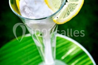 Plateau de bouchées apéritives variées présentées sur un napperon blanc, tenu par une personne en chemise blanche.
