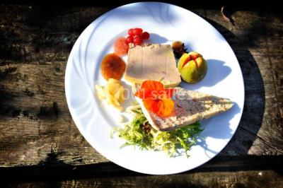 Plateau de bouchées apéritives variées présentées sur un napperon blanc, tenu par une personne en chemise blanche.
