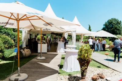 Plateau de bouchées apéritives variées présentées sur un napperon blanc, tenu par une personne en chemise blanche.