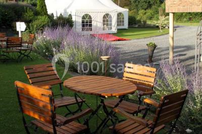 Plateau de bouchées apéritives variées présentées sur un napperon blanc, tenu par une personne en chemise blanche.