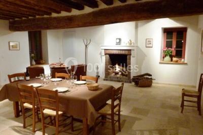 Salle lumineuse avec poutres apparentes, table décorée pour un candy bar sous une fenêtre de toit.