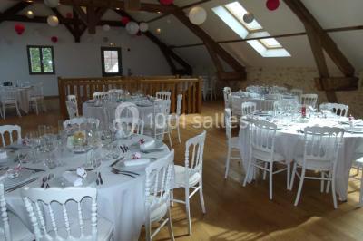 Salle lumineuse avec poutres apparentes, table décorée pour un candy bar sous une fenêtre de toit.