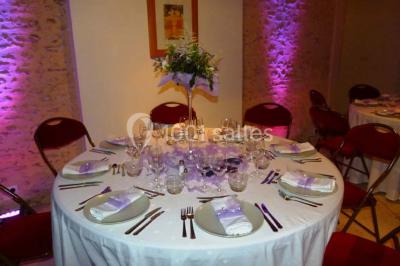 Salle lumineuse avec poutres apparentes, table décorée pour un candy bar sous une fenêtre de toit.