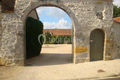Salle lumineuse avec poutres apparentes, table décorée pour un candy bar sous une fenêtre de toit.