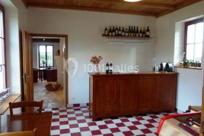 Salle lumineuse avec poutres apparentes, table décorée pour un candy bar sous une fenêtre de toit.