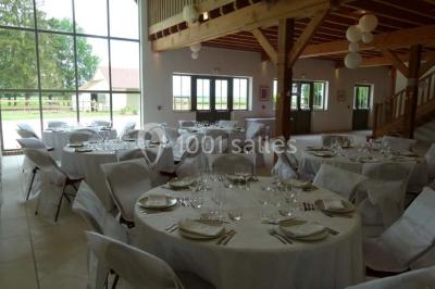 Salle lumineuse avec poutres apparentes, table décorée pour un candy bar sous une fenêtre de toit.