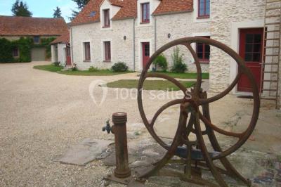 Salle lumineuse avec poutres apparentes, table décorée pour un candy bar sous une fenêtre de toit.