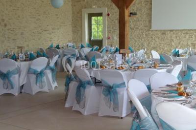 Salle lumineuse avec poutres apparentes, table décorée pour un candy bar sous une fenêtre de toit.