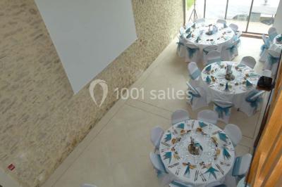 Salle lumineuse avec poutres apparentes, table décorée pour un candy bar sous une fenêtre de toit.