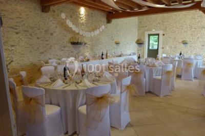 Salle lumineuse avec poutres apparentes, table décorée pour un candy bar sous une fenêtre de toit.