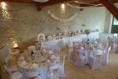 Salle lumineuse avec poutres apparentes, table décorée pour un candy bar sous une fenêtre de toit.