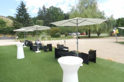 Miniature Location salle Ternand (Rhône) - Domaine des Pierres Dorées #2 Chambre lumineuse avec lit double, chaises colorées, table basse et accès à une salle de bain moderne.