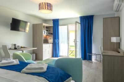 Miniature Location salle Ternand (Rhône) - Domaine des Pierres Dorées #19 Chambre lumineuse avec lit double, chaises colorées, table basse et accès à une salle de bain moderne.