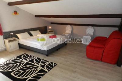 Miniature Location salle Ternand (Rhône) - Domaine des Pierres Dorées #18 Chambre lumineuse avec lit double, chaises colorées, table basse et accès à une salle de bain moderne.