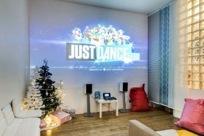 Table de fête décorée avec vaisselle élégante, sapin de Noël illuminé et cheminée allumée en arrière-plan.