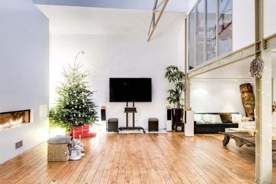 Table de fête décorée avec vaisselle élégante, sapin de Noël illuminé et cheminée allumée en arrière-plan.