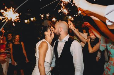 Table de fête décorée avec vaisselle élégante, sapin de Noël illuminé et cheminée allumée en arrière-plan.