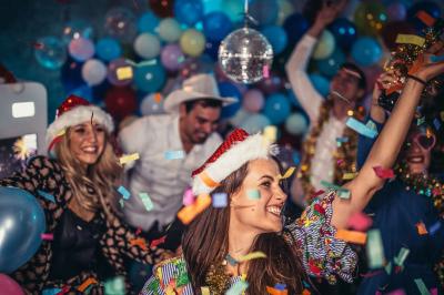 Table de fête décorée avec vaisselle élégante, sapin de Noël illuminé et cheminée allumée en arrière-plan.