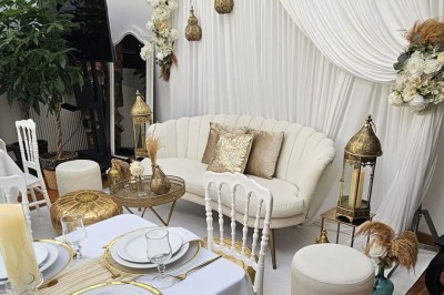 Table de fête décorée avec vaisselle élégante, sapin de Noël illuminé et cheminée allumée en arrière-plan.