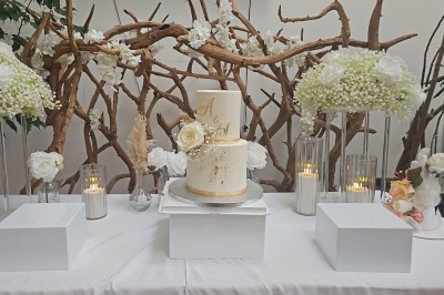 Table de fête décorée avec vaisselle élégante, sapin de Noël illuminé et cheminée allumée en arrière-plan.