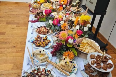 Table de fête décorée avec vaisselle élégante, sapin de Noël illuminé et cheminée allumée en arrière-plan.