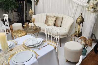 Table de fête décorée avec vaisselle élégante, sapin de Noël illuminé et cheminée allumée en arrière-plan.