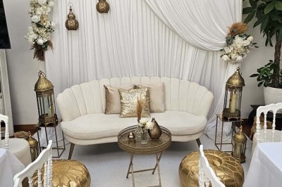 Table de fête décorée avec vaisselle élégante, sapin de Noël illuminé et cheminée allumée en arrière-plan.