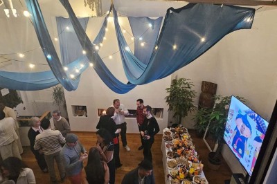 Table de fête décorée avec vaisselle élégante, sapin de Noël illuminé et cheminée allumée en arrière-plan.