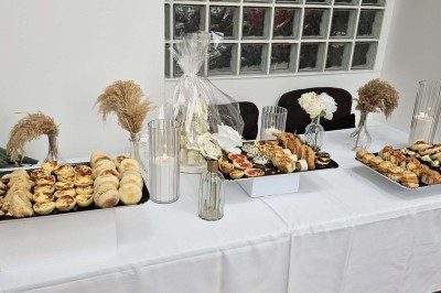 Table de fête décorée avec vaisselle élégante, sapin de Noël illuminé et cheminée allumée en arrière-plan.