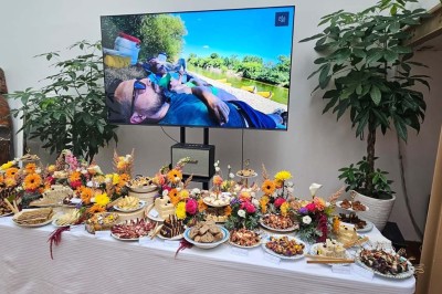 Table de fête décorée avec vaisselle élégante, sapin de Noël illuminé et cheminée allumée en arrière-plan.