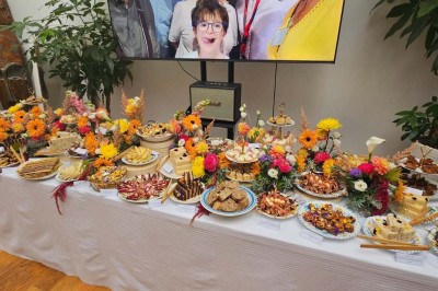 Table de fête décorée avec vaisselle élégante, sapin de Noël illuminé et cheminée allumée en arrière-plan.