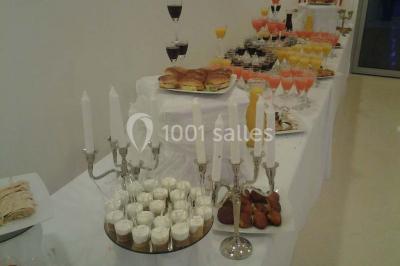 Assortiment de desserts avec verrines, fruits frais, macarons et coulis, disposés sur des assiettes blanches.