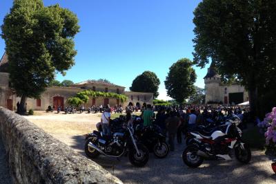 Château en pierre éclairé à la tombée de la nuit, entouré d'arbres et surmonté d'un ciel nuageux.