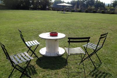 Château en pierre éclairé à la tombée de la nuit, entouré d'arbres et surmonté d'un ciel nuageux.