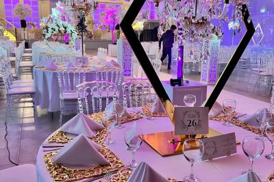 Voiture de sport verte aux portes papillon ouvertes, entourée de fumée et d'une foule dans un lieu éclairé.