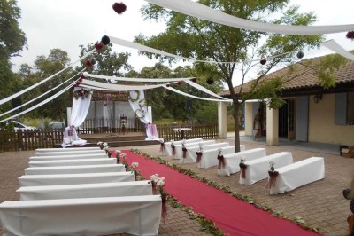 Mobilier de jardin en résine tressée disposé sur une terrasse en béton, entouré d'arbres et de verdure.