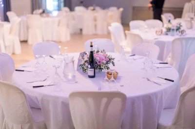 Mobilier de jardin en résine tressée disposé sur une terrasse en béton, entouré d'arbres et de verdure.