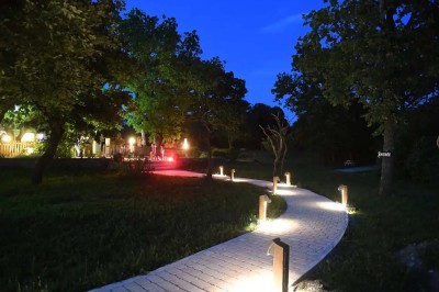 Mobilier de jardin en résine tressée disposé sur une terrasse en béton, entouré d'arbres et de verdure.