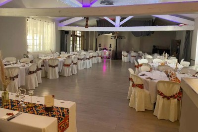 Mobilier de jardin en résine tressée disposé sur une terrasse en béton, entouré d'arbres et de verdure.