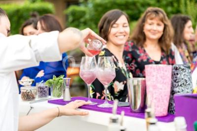 Salle de bain avec baignoire, lavabo moderne sur meuble noir, miroir mural et lumière naturelle par une fenêtre.